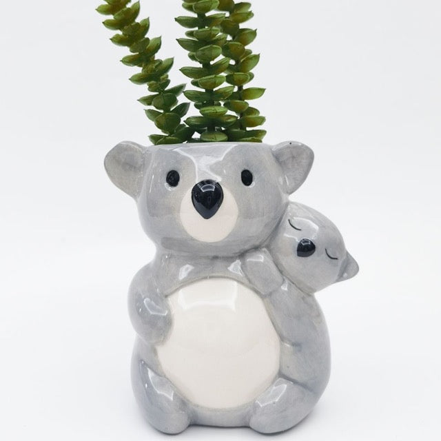 Ceramic koala planter with a small koala on its back, set against a white background.