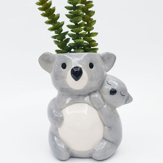 Ceramic koala planter with a small koala on its back, set against a white background.