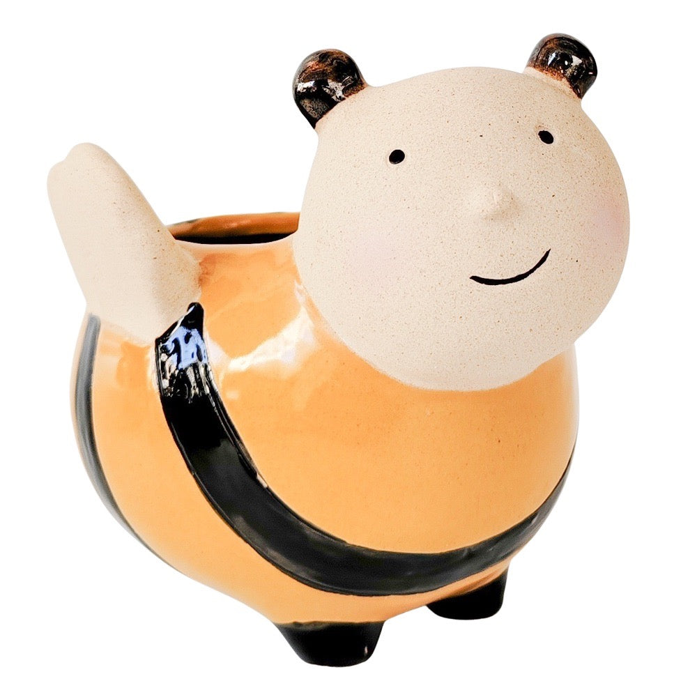 Ceramic planter designed to look like a bee with a face on a white background