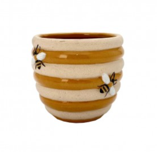 A ceramic planter with beige and brown stripes featuring bee designs.