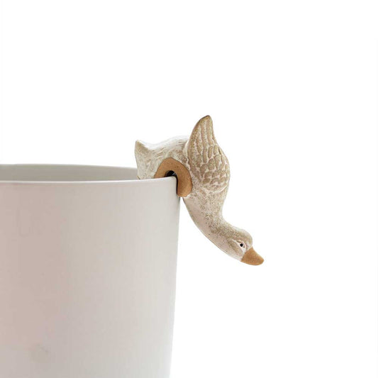 A ceramic decorative duck designed to perfectly perch on the edge of plant pot