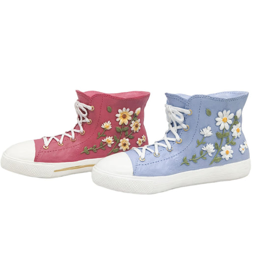 Pair of high-top sneaker- shaped planters with floral designs on a white background