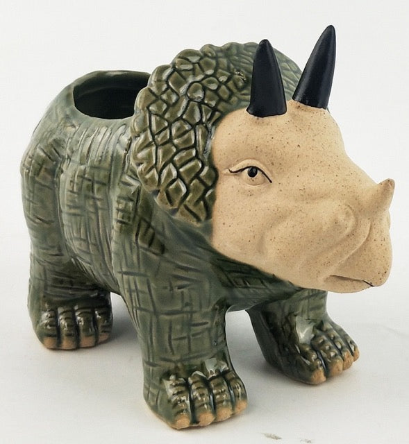 Ceramic triceratops dinosaur planter with textured surface and black horns on a white background