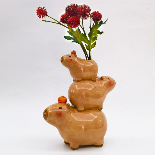 Stacked ceramic capybara figures on a white background 
