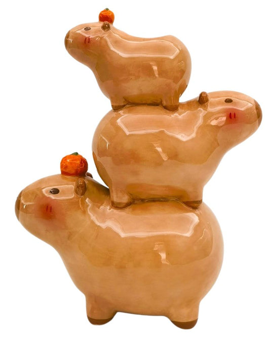 Stacked ceramic capybara figures on a white background