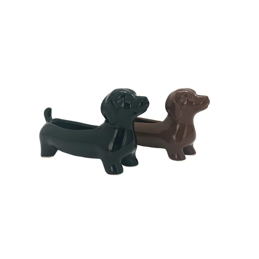 Two ceramic pots shaped like dachshunds, one in black color and the other in brown, with a drainage hole at the bottom.