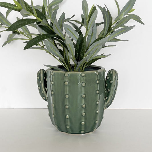 Green cactus-shaped pot with a plant on a white background